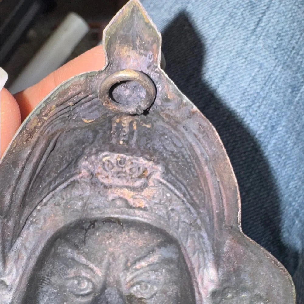 Vintage enameled metal decorative mask of an Asian man's face.